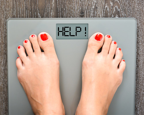 Feet on scale with text that says help